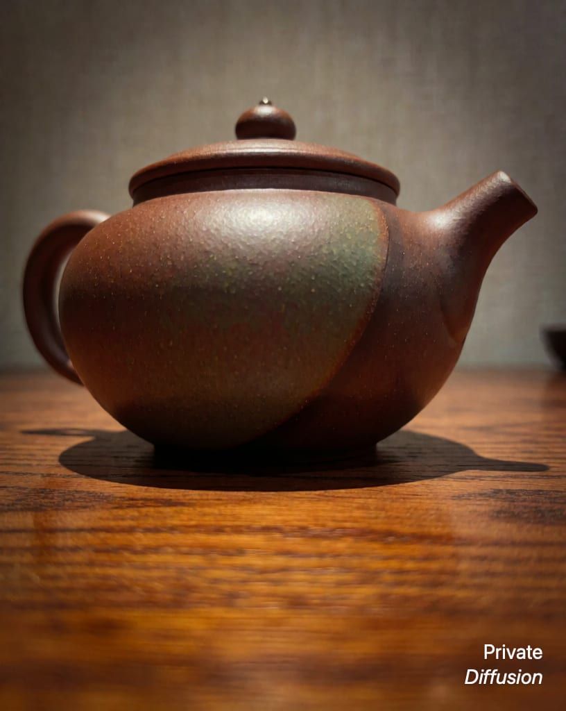 a ceramic teapot on a wooden table, with low angle added