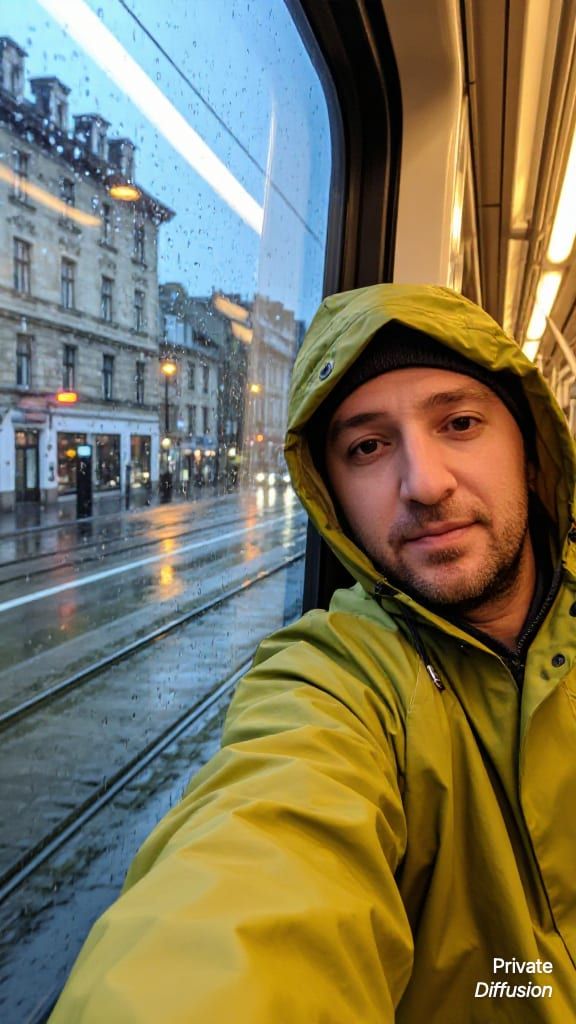 An adult traveler takes a rainy evening selfie inside a tram.